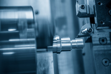 The CNC lathe machine cutting the thread    at the metal parts. The hi-technology automotive parts manufacturing process by turning machine.