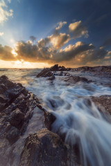 Nature landscape, seascape, motion blurred of beach wave hitting rocks with dramatic clouds sunrise or sunset scenery at Pantai Tanjung Jara, Dungun.