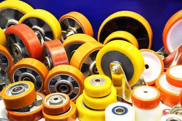 Group of different size and diameter industrial small wheels in warm yellow and orange colors for...