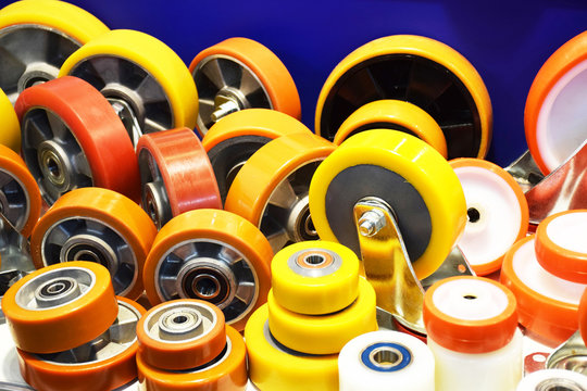 Group of different size and diameter industrial small wheels in warm yellow and orange colors for sale. Heavy Duty Fixed Polyurethane Industrial trolley Swivel Rubber Caster Wheels.