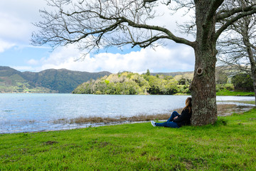 Fototapeta na wymiar Girl looking over Sete Cidades lake into the mountains, Azores, Portugal.
