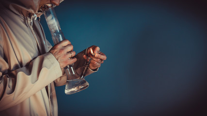 The person smoking marijuana with bong, close-up.