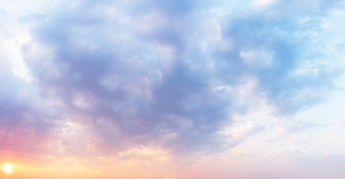 Fantastic sunset sky in pastel colors in shades from purple to orange. Clouds background.