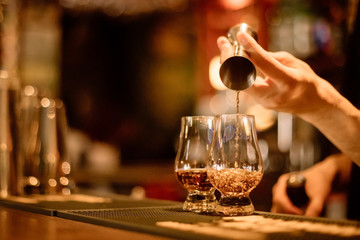 Bartender pouring whisky in a glass