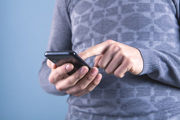 man holding a telephone on a gray background