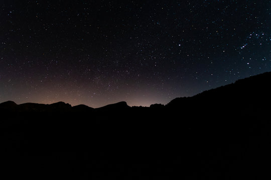 night photos on the Teide volcano in Tenerife. Images of the starry sky at night with the glow of the cities on the horizon