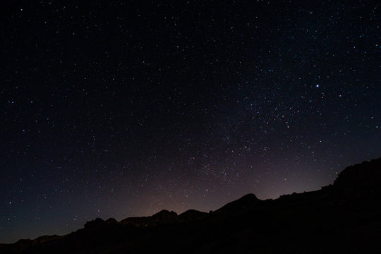 night photos on the Teide volcano in Tenerife. Images of the starry sky at night with the glow of the cities on the horizon