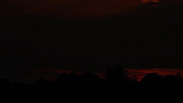 Fast summer sunset. Time lapse. Sun sets behind trees. Muskoka, Ontario, Canada. Note: A couple of very small spots on the image can be seen when viewed at full size.