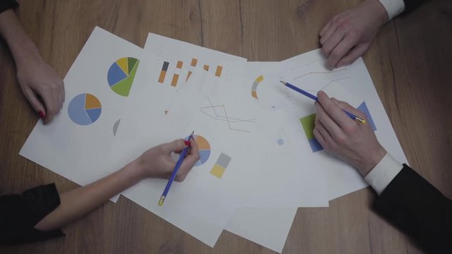 Above view shot of graphic data templates table with unrecognizable business people analyzing growth rates and trends. Workplace. Office space.