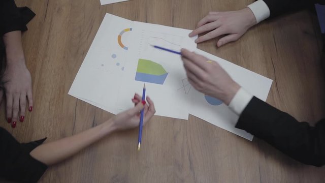 Above view shot of graphic data templates table with unrecognizable business people analyzing growth rates and trends. Workplace. Office space.