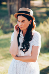 Fototapeta na wymiar attractive girl in a hat and a white dress