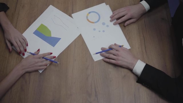 Above view shot of graphic data templates table with unrecognizable business people analyzing growth rates and trends. Workplace. Office space.