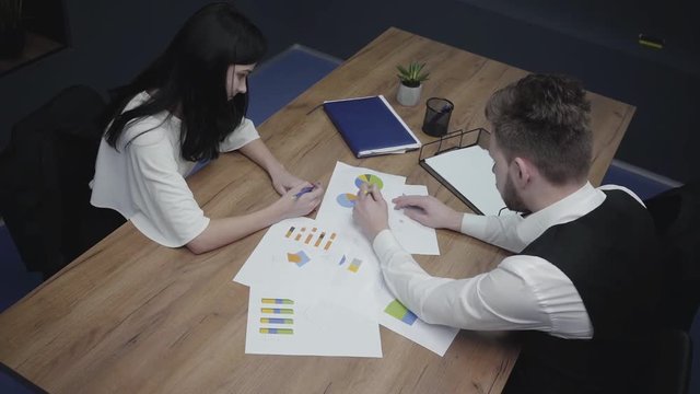 Top view shot of graphic data templates table with business people analyzing growth rates and trends. Workplace. Office space.