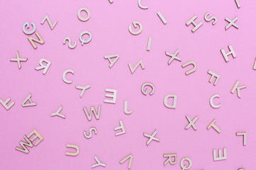 Wooden ABC alphabet letters on pink background