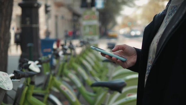 Female booking a public rental bicycle on mobile application