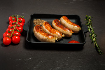 square pan with four fried sausages, ketchup and caraway seeds