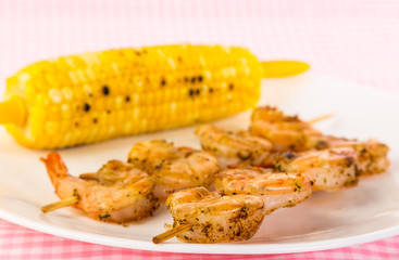 Selective Focus on Grilled Shrimp Shish Kabob on Plate with Roast Corn on the Cob - Shallow DOF