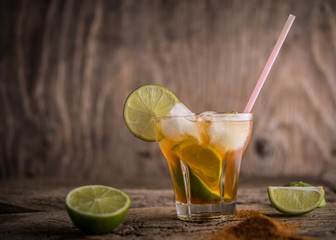 Caipirinha coctail, lemon and cinnamon on old wooden rustic table