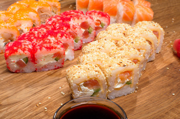 Set sushi rolls on a wooden table with tents soy sauce and ginger. Tasty dinner. Ukrainian inerpretation for Japanis kitchen
