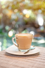 Hot coffee late over blurred garden with vintage warm light