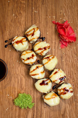 Unusual sushi rolls on a wooden table. Ukrainian sushi rolls with baked cheese and crabs