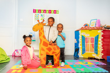 Group of black boys and girl hold drawn giraffe