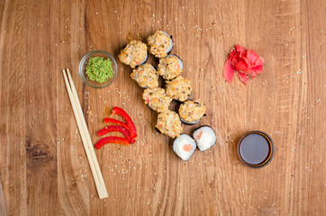 Unusual sushi rolls on a wooden table. Ukrainian sushi rolls with baked cheese and crabs