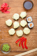 Unusual sushi rolls on a wooden table. Ukrainian sushi rolls with baked cheese and crabs