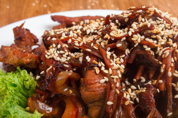 Asian hot veal salad with soy sauce and sesame. Restaurant dish on a white plate