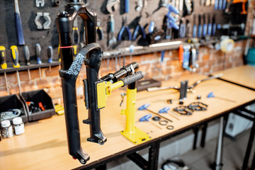 Bicycle fork during the repairing process hanging on a stand in the bicycle workshop