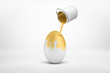 3d rendering of small silver paint bucket turned upside down with golden paint pouring on big white egg isolated on white background