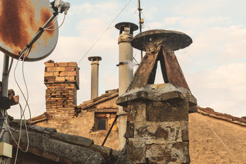 Plakat Old chimneys and rusty satellite dish, sky on background