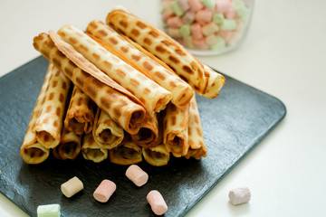 waffle tubes on black Board and marshmallow on white background