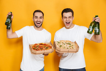 Image of two joyous men bachelors 30s in white t-shirts holding pizza boxes and beer bottles