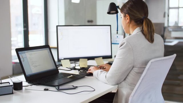 business, programming and technology concept - female programmer with computer working and giving folder to her colleague at office