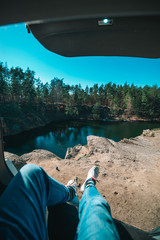 man sitting in car trunk looking at lake. beautiful landscape view