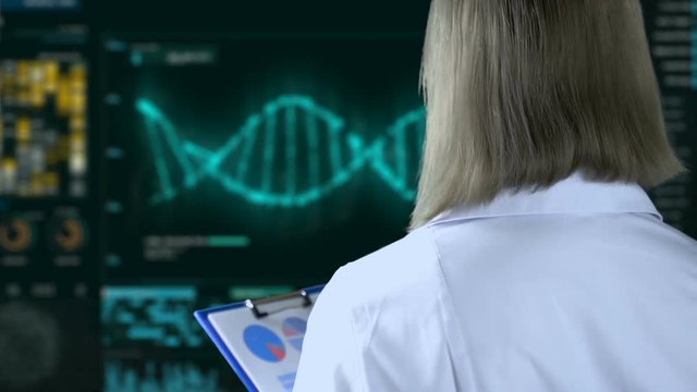 Geneticist watching DNA analysis process on screen, genetic modifications. Female scientist working in laboratory, scientific experiments, research