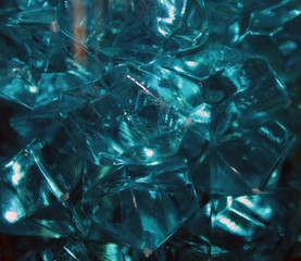 Blue crystals of glass with highlights of light on them, blur, close-up, abstraction.