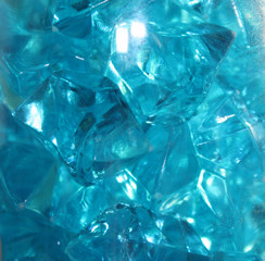 Blue crystals of glass with highlights of light on them, blur, close-up, abstraction.