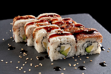 Uramaki rolls served on stone slate plate.