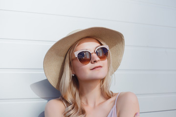 Fototapeta premium Young brunette girl in black standing outside and watching the sunset in the city, the sun shines brightly, fashionable clothes on a girl, hipster style, tattoo, street photo, mood, freedom