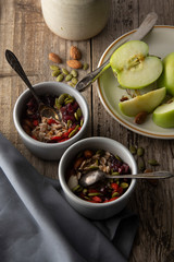 Healthy breakfast.Two bowls of muesli with oats, nuts and dried fruits - apples, resins, pumpkin seeds and almonds on wooden table. Top view. Rustic style.
