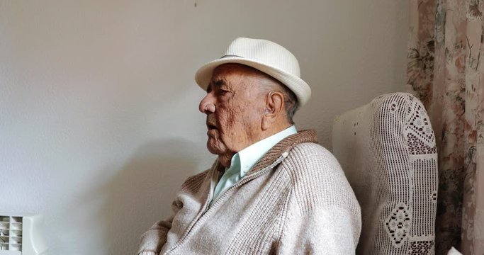 Elderly man talking alone at home