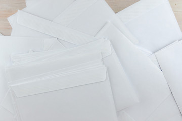 outgoing correspondence: a lot of empty white envelopes on a wooden desk
