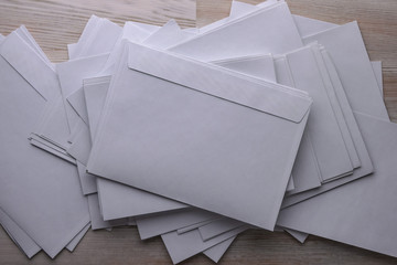 outgoing correspondence: a lot of blank white envelopes on a wooden desk in the office