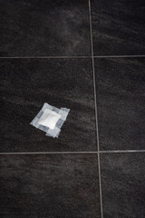Bandage gauze with tape on grey tile floor. Top view.