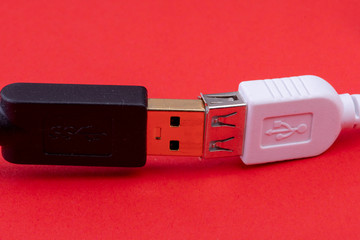 data cable extension plug white and black cable together on red background