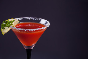 Bloody Mary Cocktail in glass. Tomato Bloody Mary spicy drink on theblack background.