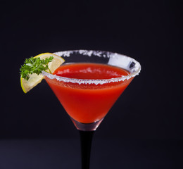Bloody Mary Cocktail in glass. Tomato Bloody Mary spicy drink on the black background.