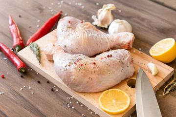chicken legs with spices on the cutting Board, raw chicken, lemon, chili, garlic